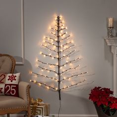 a christmas tree is lit up in the corner of a room with a chair and fireplace