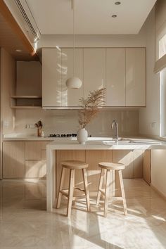 a kitchen with two stools in front of an island