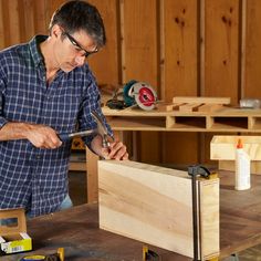 a man is working with wood in his workshop while holding a pair of pliers