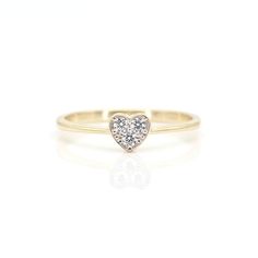 a yellow gold ring with a heart shaped diamond in the center, on a white background