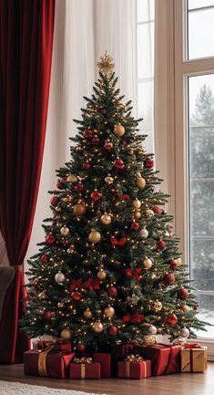 a decorated christmas tree in front of a window