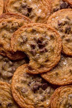 chocolate chip cookies are piled on top of each other in a pile and ready to be eaten