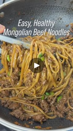 someone is cooking noodles in a pan with meat