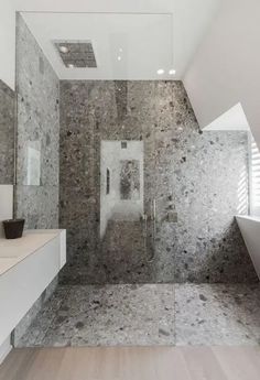 a modern bathroom with marble walls and flooring, along with a white bathtub