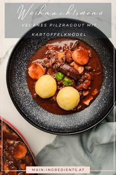 a black bowl filled with meat and potatoes on top of a white countertop next to a