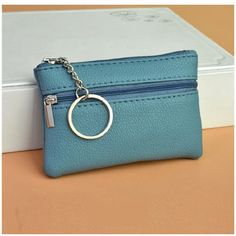 a small blue purse with a keychain hanging from it