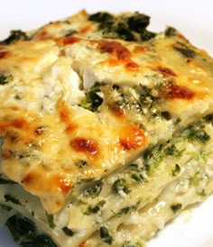 a white plate topped with lasagna covered in cheese and broccoli