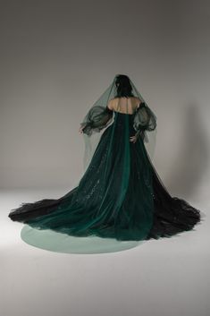 a woman in a long green dress and veil