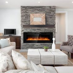 a living room filled with furniture and a fire place in the middle of the room