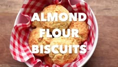 three biscuits in a red and white basket with the words almond flour biscuits