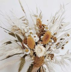 a vase filled with lots of white and brown flowers