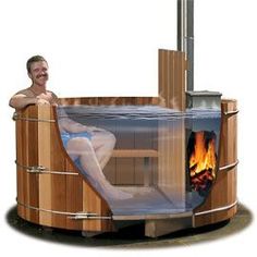 a man sitting in a wooden hot tub next to a fire and water fountain with flames coming out of it