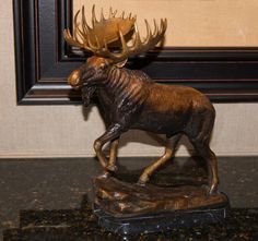 a bronze statue of a moose with antlers on it's head