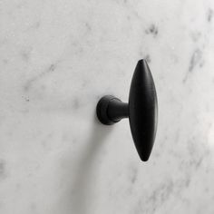 a black door handle on a white marble surface