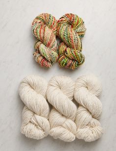 three skeins of yarn sitting next to each other on a white counter top