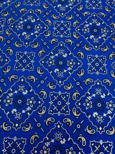 a blue and gold patterned table cloth with white flowers on it, in an ornate pattern