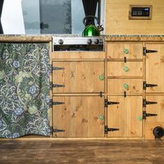 a kitchen with wooden cabinets and an oven in the center, next to a window