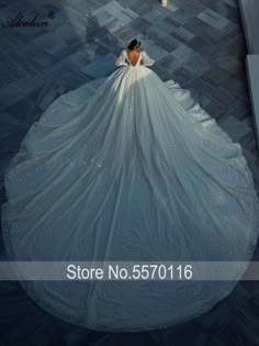 a woman in a wedding dress is looking down at the floor with her back to the camera