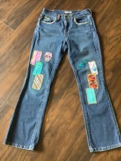 This is a vintage Levi's blue jeans size 4.  Hand embroidered with vintage fabric, patches and embroidery. Blue Cotton Patchwork Flare Jeans, Embroidered Denim Blue Cotton Jeans, Embroidered Cotton Jeans In Denim Blue, Embroidered Denim Blue Cotton Flare Jeans, Casual Denim Jeans With Multicolor Embroidery, Casual Jeans With Multicolor Embroidery, Fitted Embroidered Dark Wash Jeans, Recycled Denim Straight Leg Jeans With Patches, Embroidered Straight Leg Denim Jeans