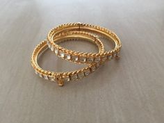 *This is Gold Finish Kundan Bangles pair.Its Perfect for Wedding Occasion as well as Unique and Ethnic Traditional Bangle to gift and Also Bridal wear to match with Wedding Outfits. *Its made from Silver n Copper mix material and 100% Handmade. *Its available in Various Sizes like 2,2.2,2.4,2.6 Etc Its white kundan combination like shown in picture. *Its open able Screwed Bangles Pair. *All Kundan stones set with silver foils handsetting method and long last guarantee of its workmanship.It is Wh Festive Bangle With Intricate Design For Reception, Kundan Meenakari Bangle For Reception, Reception Kundan Bangle With Meenakari, Meenakari Kundan Bangle For Reception, Reception Meenakari Kundan Bangle, Temple Jewelry Style Tilla Bangle For Reception, Gold Bracelets With Tilla For Reception, Gold Bracelets For Diwali Reception, Gold Bracelet With Stone Work For Reception