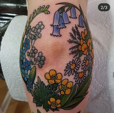 a woman's leg with flowers and birds on it