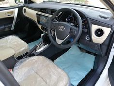 the interior of a car with leather seats and steering wheel covers covered in blue tarp