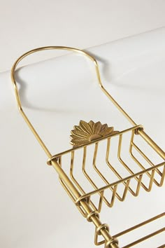 a gold metal rack with four candles on it and a candle holder in the shape of a leaf