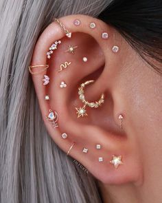 a woman wearing ear piercings with stars and moon designs