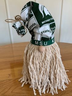 a green and white hat sitting on top of a wooden table