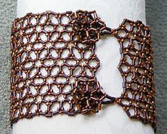 a close up of a napkin on a white cloth with brown beadwork around it