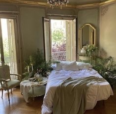 a large bed sitting in the middle of a bedroom next to two tables and chairs