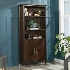 a wooden bookcase with plants and books on it