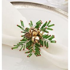 a small christmas decoration on top of a white plate with silverware and napkins