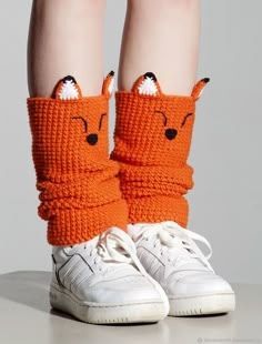 the legs of a child wearing orange knitted socks