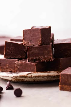 chocolate fudges stacked on top of each other in front of some pieces of cake