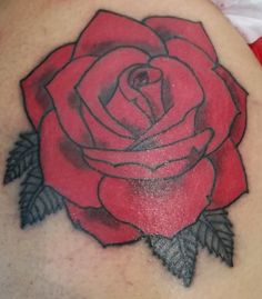 a rose tattoo on the back of a woman's shoulder