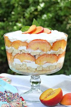 peaches and cream trifle in a glass dish on top of a white table cloth