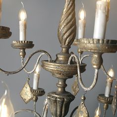 an antique chandelier with candles lit in the middle and one light on each side