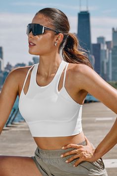 Looking for a top with a twist? The White Scoop Neck Sleeveless Crop Top features a unique overlay design, resembling a sports bra layered over a cami. Both in crisp white, this piece combines style and intrigue, making it a standout addition to your wardrobe. Featured Line: SOL Product code: CAA04A4G021CC Features:  Knit Scoop neckline Sleeveless Cropped Lining: 85%POLYAMIDE,15%SPANDEX Material: 75%POLYAMIDE,25%SPANDEX. White Sleeveless Tank Top With Removable Bra Pads, Athleisure Sleeveless Sports Bra With Straps, White Sporty Crop Top With Built-in Bra, White Sports Bra With Removable Pads, White Sports Bra With Removable Pads For Summer, Summer White Sports Bra With Removable Pads, White Strappy Yoga Activewear, White Yoga Activewear With Straps, White Strapped Yoga Activewear