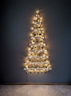 a christmas tree made out of lights on the side of a wall in a room