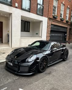 a black sports car parked in front of a building