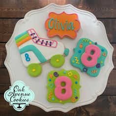 decorated cookies on a white plate with the word glyvia written in large letters