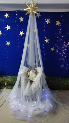 a bed with a white sheet and some stars on the wall next to it in front of a blue background