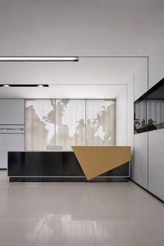 an office lobby with white walls and black counter tops, along with a large screen on the wall