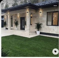 a house that has grass in front of it and lights on the side of the house