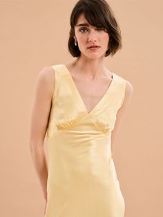 a woman in a yellow dress posing for the camera