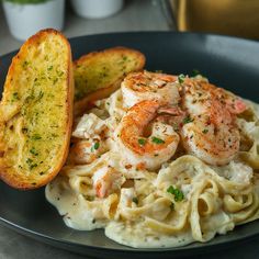 pasta with shrimp and garlic bread on a plate