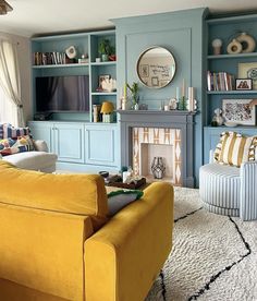 a living room filled with furniture and a fire place next to a tv mounted on a wall