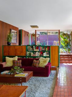 a living room filled with furniture and lots of books on the shelves next to it