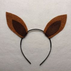 a close up of a mouse ears headband on a white surface with brown felt